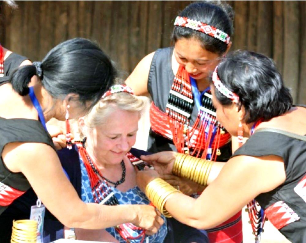 A tourist is seen trying out ornaments with a group of Naga women in one of the traditional Morungs in this picture taken during the Hornbill Festival on December 2, 2018 at the Naga Heritage Village, Kisama near Kohima. (Morung File Photo)